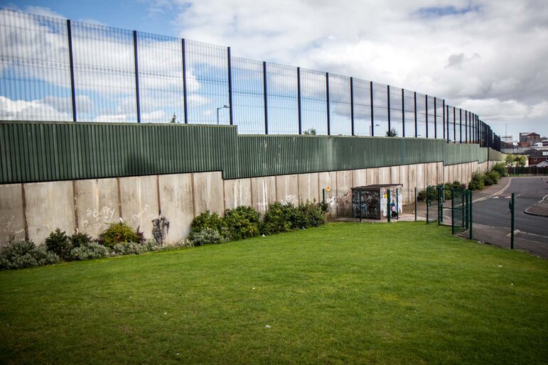 The Belfast Peace Wall — a concrete and steel barrier over 25 feet high separating communities